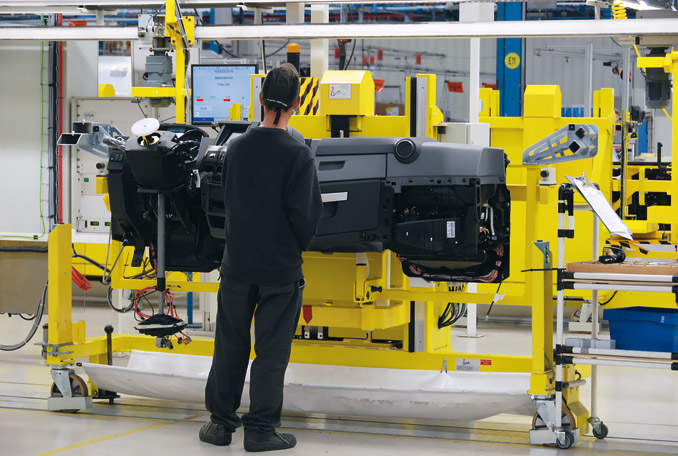 Poszczególne elementy składowe wyposażenia wnętrza kabiny, jak deska rozdzielcza, podmontowywane są na oddzielnych stanowiskach (fot. Renault Trucks)