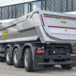 Zamontowana na podwoziu 5-osiowym wywrotka Meiller P536 o nominalnej objętości skrzyni 20 m3 i nominalnym obciążeniu do 36 t ma solidnie wykonaną stalową skrzynię, a wypróbowane funkcje bezpieczeństwa obejmują wizualny sygnał sterujący w kabinie i stabilizatory zwiększające stabilność podczas wywrotki. Pakiet bezpieczeństwa ogólnego dopełnia pilot zdalnego sterowania Meiller i.s.a.r. control, ułatwiający sterowanie wszystkimi funkcjami wywrotki tylnej z bezpiecznej odległości (fot. Meiller Kipper)