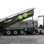 Fliegl Stonemaster Greenlight - Stożkowata mulda, która rozszerza się ku tyłowi, umożliwia szybkie i całkowite usunięcie przewożonego materiału, ponadto zmniejszył się opór powietrza i opory toczenia. Rynna
w kształcie stożka jest częścią obszernego pakietu aerodynamicznego wywrotki Fliegl. Należą do nich również specjalne przegrody i membranowa klapa tylna (z podwójnym przegubem), która znacznie zmniejsza turbulencje
powietrza z tyłu. W sumie wszystkie te modyfikacje pozwalają na zmniejszenie zużycia paliwa do 8%. Inne praktyczne zalety wywrotki Greenlight to niski próg załadunkowy i nisko położony środek ciężkości pojazdu.
Skrzynię typu half-pipe wykonano z wyjątkowo odpornej na zużycie stali (HB 400/450). Aby uzyskać większą objętość, przednia ściana i mocowanie cylindra hydraulicznego są pochylone (fot. Fliegl)